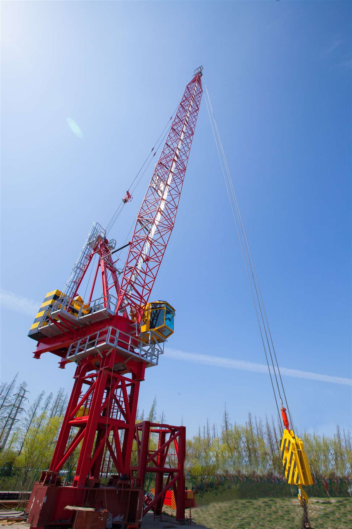 Favelle Favco's new MK380F-H12 in red with a yellow cabin, boom up, against a bright blue sky 