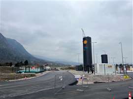 A newly constructed LNG fuelling station in Bonneville, France sitting in a mountain setting with a large, dark grey LNG tank