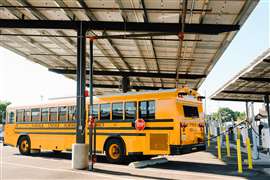 An electric school bus is plugged in under the solar canopy at Turlock Unified School District. (Photo: Schneider Electric)