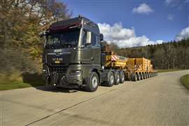grey MAN tractor unit hauling a yellow multi-axle trailer