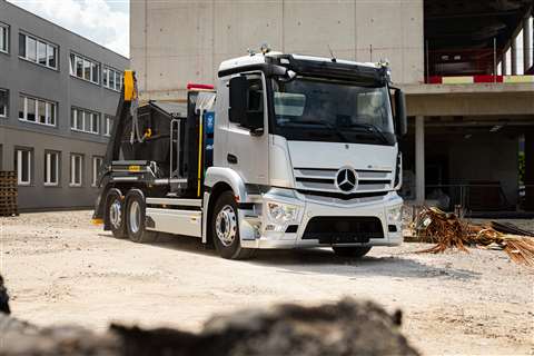 Silver skip loader truck